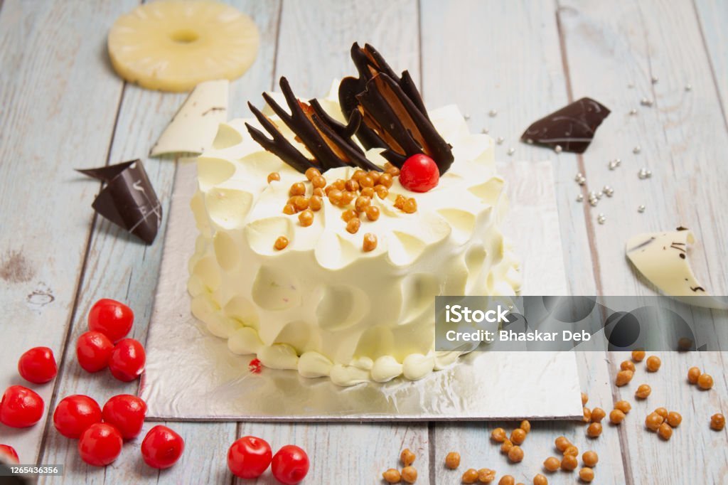 butterscotch cake decorated with strawberry over wooden background